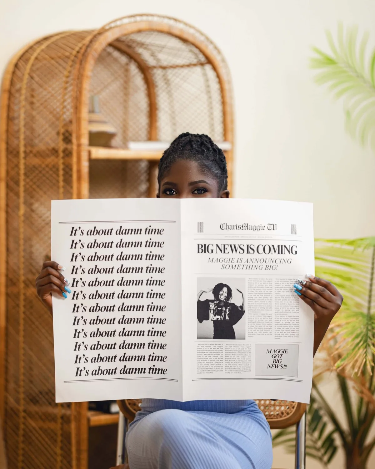 Woman in a rattan chair holding a mock newspaper that hides most of her face